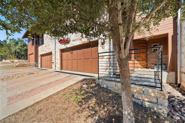 view of side of home with stone siding and dirt driveway
