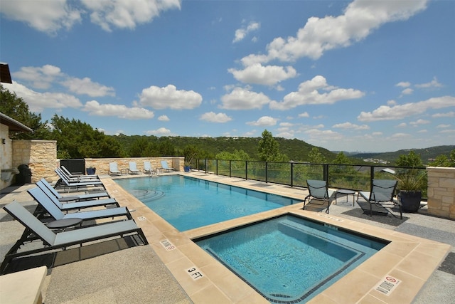 pool featuring fence, a community hot tub, and a patio
