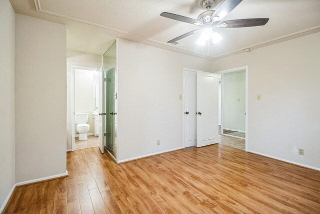 7920 Rockwood Ln Unit 202, Austin, TX 78757 - unfurnished bedroom with light wood-style floors, baseboards, and ensuite bathroom