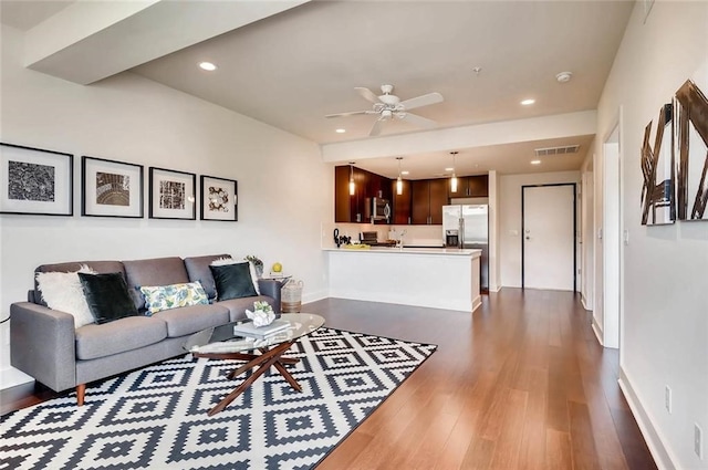 living room featuring a ceiling fan, visible vents, dark wood finished floors, and baseboards