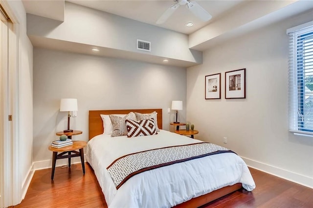 bedroom featuring multiple windows, wood-type flooring, and ceiling fan