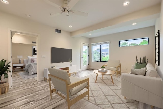 living room featuring baseboards, light wood-style flooring, visible vents, and recessed lighting
