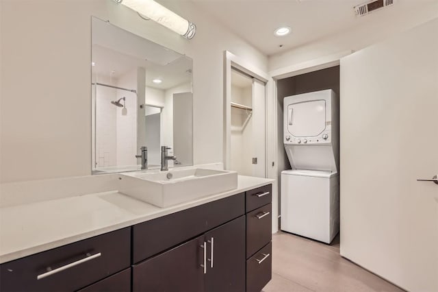 full bath with stacked washer and clothes dryer, recessed lighting, visible vents, vanity, and a shower