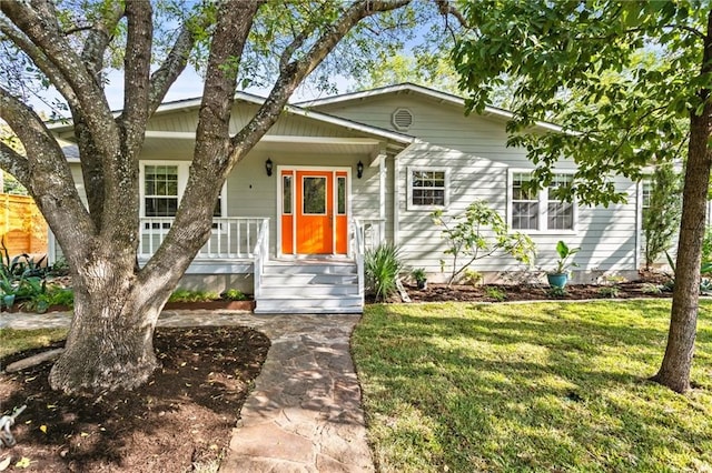 view of front of home with covered porch and a front lawn