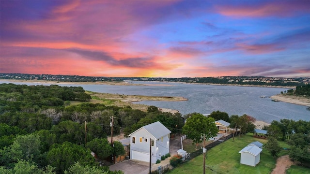 aerial view at dusk featuring a water view