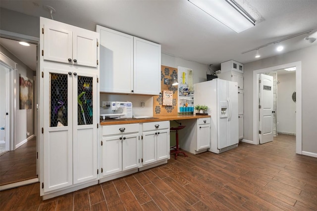 kitchen with dark wood-type flooring, track lighting, white cabinetry, white fridge with ice dispenser, and wooden counters