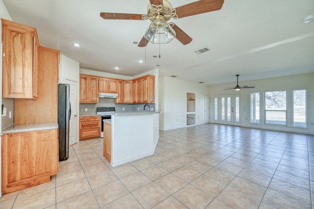 1504 Timber Valley Ln, Granite Shoals, TX 78654 - kitchen featuring freestanding refrigerator, ceiling fan, range with electric stovetop, under cabinet range hood, and backsplash