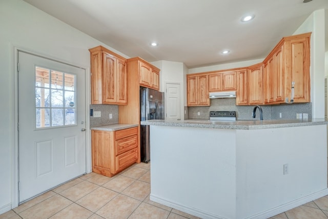 1504 Timber Valley Ln, Granite Shoals, TX 78654 - kitchen featuring under cabinet range hood, black fridge, range with electric stovetop, light countertops, and decorative backsplash