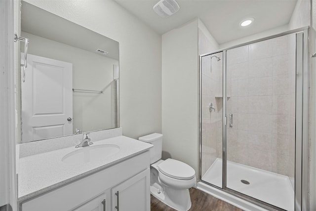 bathroom featuring walk in shower, wood-type flooring, toilet, and vanity