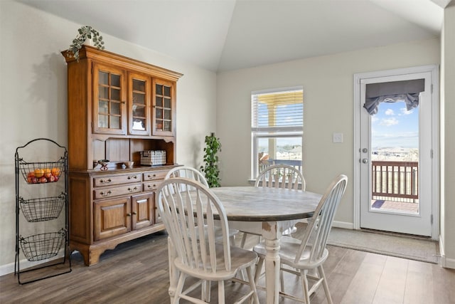 dining room featuring dark hardwood / wood-style floors and vaulted ceiling