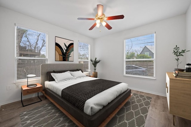 bedroom with wood finished floors, baseboards, and a ceiling fan