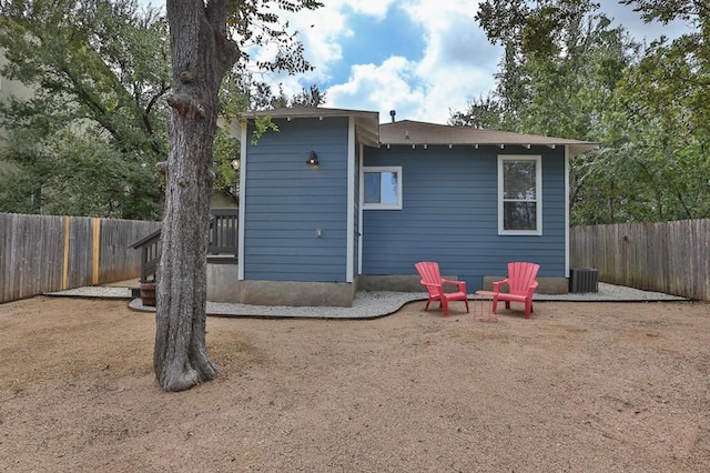rear view of house featuring a fenced backyard and central air condition unit
