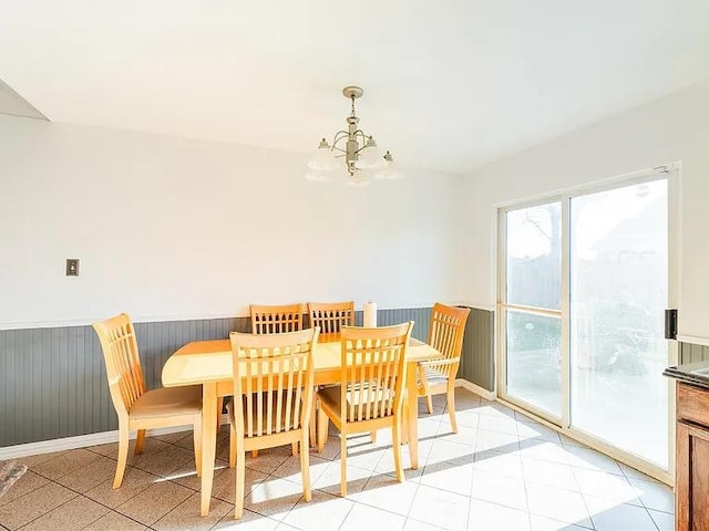 tiled dining space featuring a notable chandelier