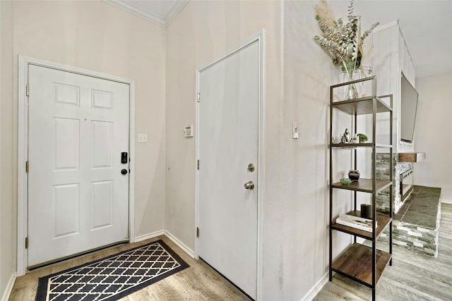 entrance foyer featuring ornamental molding and light hardwood / wood-style floors