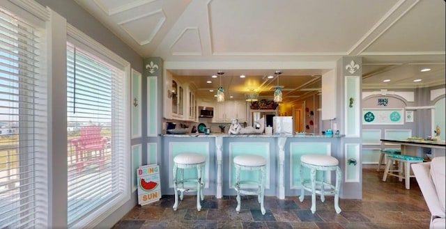 kitchen featuring pendant lighting, light stone countertops, and kitchen peninsula