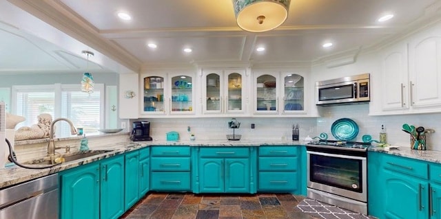 kitchen with white cabinetry, appliances with stainless steel finishes, blue cabinetry, and light stone counters