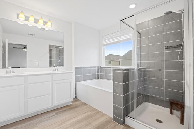 bathroom with vanity, ceiling fan, wood-type flooring, and separate shower and tub