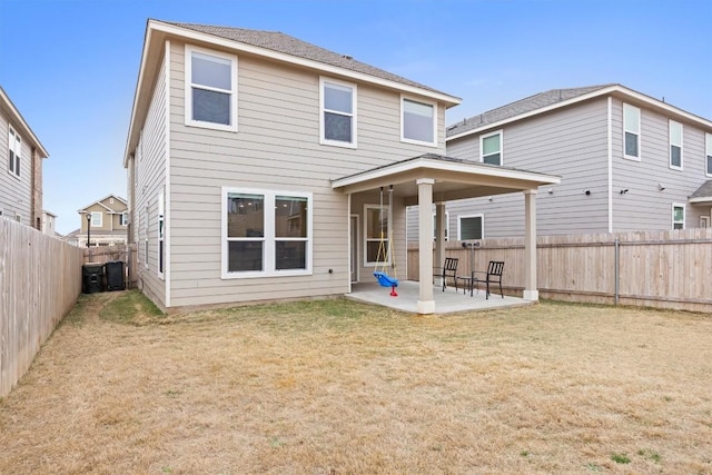 back of property with a lawn and a patio