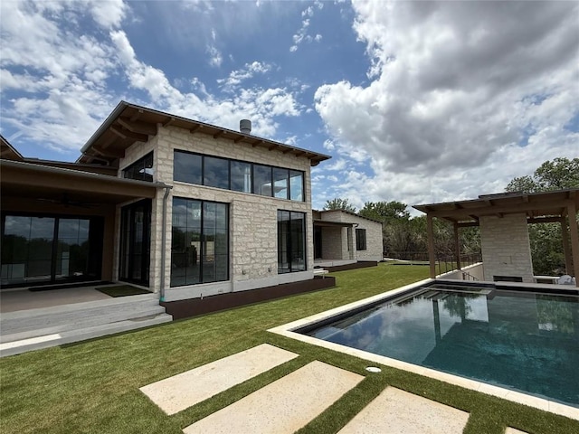 4600 Wild Cow Cv, Spicewood, TX 78669 - back of property with stone siding, an outdoor pool, a lawn, and a patio area