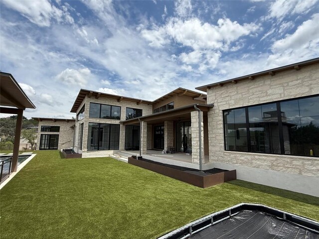 4600 Wild Cow Cv, Spicewood, TX 78669 - back of house with stone siding, a yard, and uncovered parking