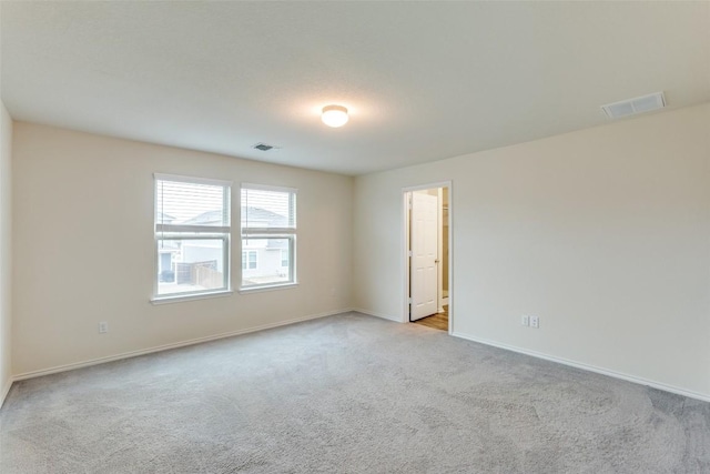 spare room featuring light carpet