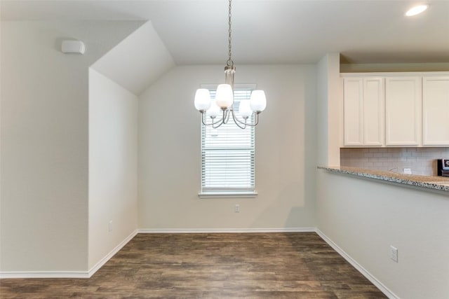 unfurnished dining area featuring dark hardwood / wood-style floors and a chandelier