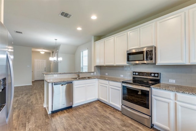 kitchen featuring sink, hanging light fixtures, stainless steel appliances, decorative backsplash, and white cabinets