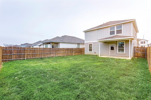 rear view of house featuring a patio and a yard