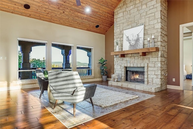 unfurnished living room with a stone fireplace, high vaulted ceiling, hardwood / wood-style floors, and wooden ceiling