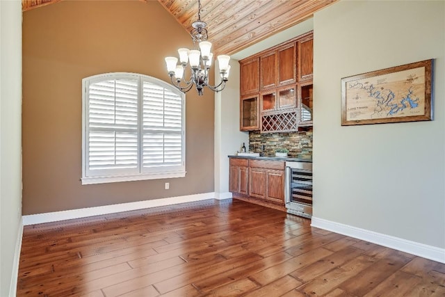 bar with dark hardwood / wood-style floors, wine cooler, tasteful backsplash, decorative light fixtures, and a chandelier