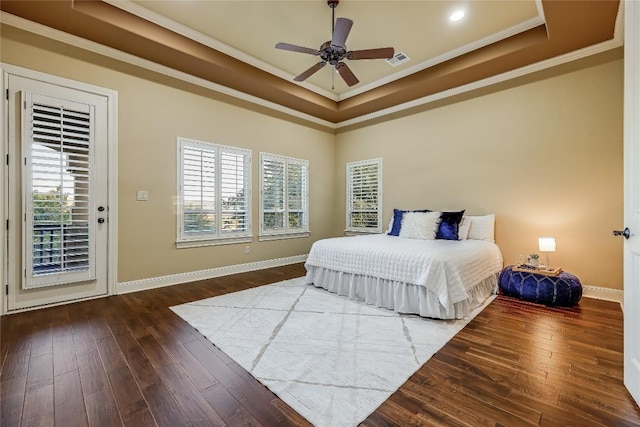 bedroom featuring a raised ceiling, crown molding, and dark hardwood / wood-style floors