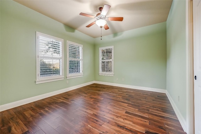 empty room with ceiling fan and dark hardwood / wood-style flooring