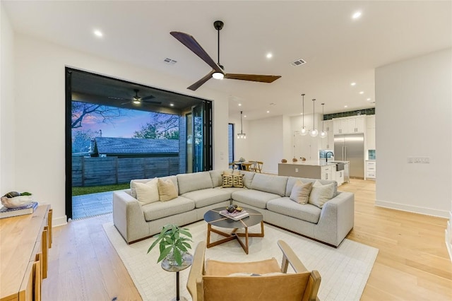 living room with ceiling fan and light hardwood / wood-style floors