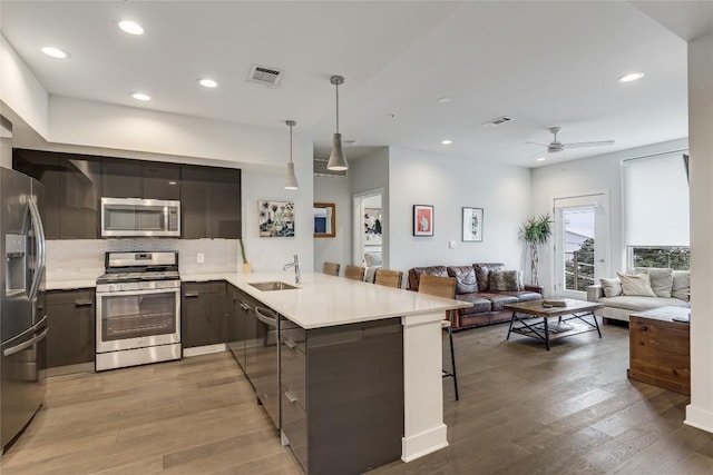 1800 E 4th St Unit 337, Austin, TX 78702 - kitchen featuring appliances with stainless steel finishes, a sink, a peninsula, open floor plan, and modern cabinets