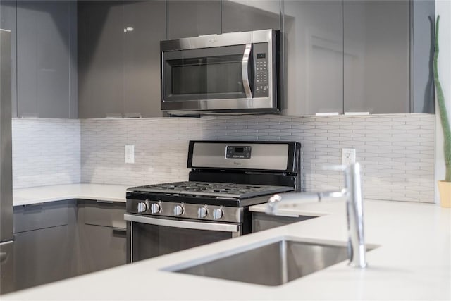 1800 E 4th St Unit 337, Austin, TX 78702 - kitchen featuring appliances with stainless steel finishes, gray cabinetry, modern cabinets, and backsplash