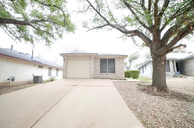 ranch-style home featuring a garage and central AC unit