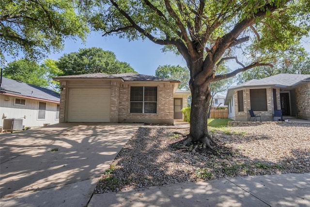 9145 Swanson Ln, Austin, TX 78748 - view of front of house with fence, cooling unit, brick siding, concrete driveway, and an attached garage