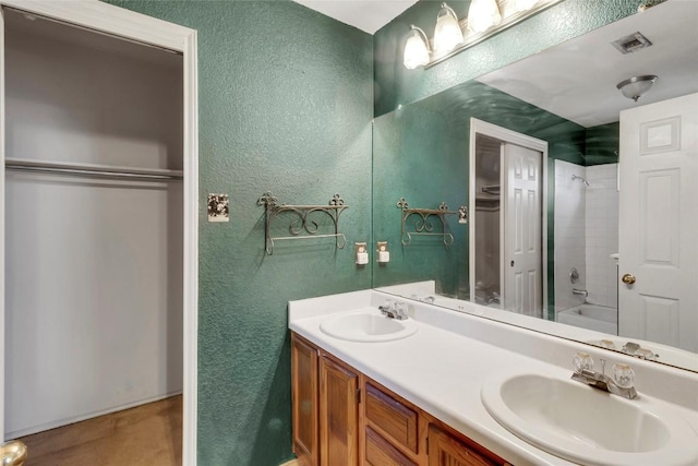 9145 Swanson Ln, Austin, TX 78748 - full bathroom with visible vents, a sink, a textured wall, and double vanity