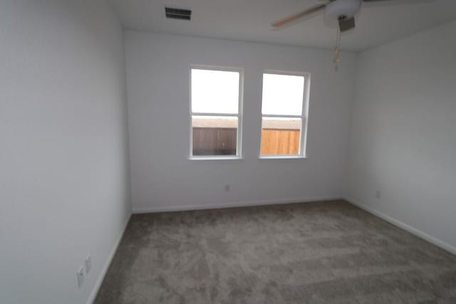 carpeted spare room with ceiling fan