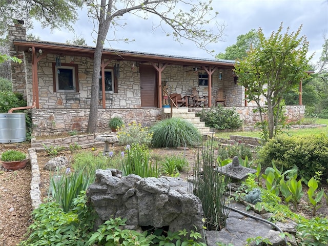 525 Plant Lady Ln, Dripping Springs, TX 78620 - view of front facade featuring stone siding, covered porch, and a chimney