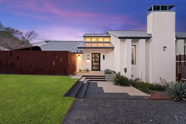 back house at dusk with a yard