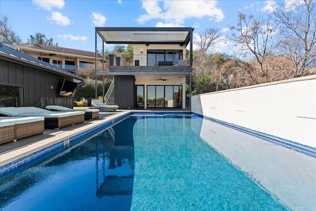 back of property with ceiling fan, a patio area, and a balcony