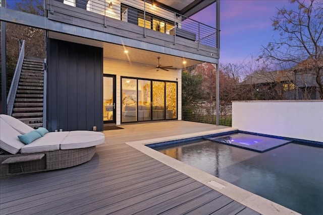 exterior space with a jacuzzi, ceiling fan, and a deck