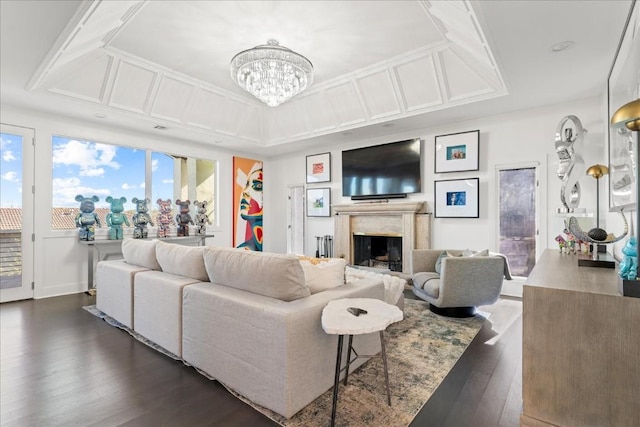 living room featuring a high end fireplace, dark hardwood / wood-style floors, and a notable chandelier