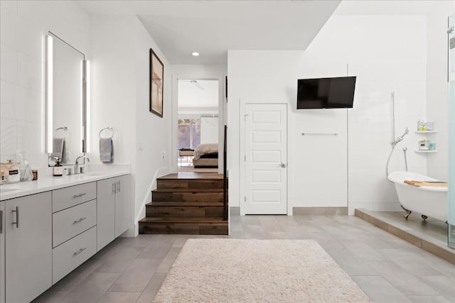 bathroom with vanity, tile patterned flooring, and a tub