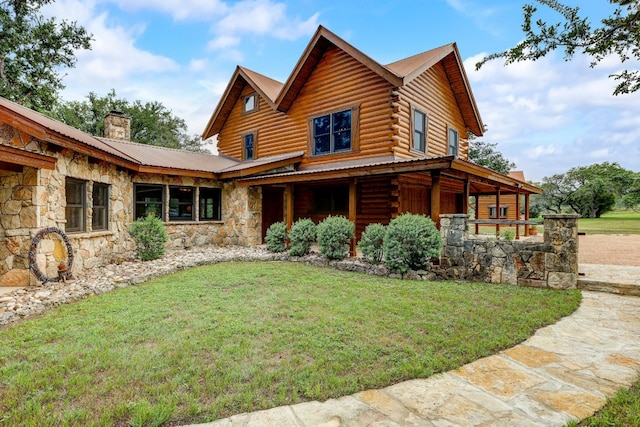 exterior space with log exterior, stone siding, a chimney, metal roof, and a front lawn