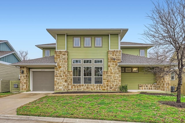 view of front of house with cooling unit, a garage, and a front yard