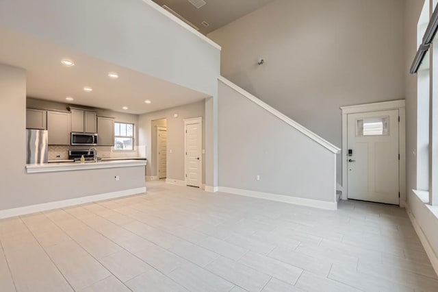 10610 Wills Loop, Austin, TX 78717 - unfurnished living room with a high ceiling, stairs, and recessed lighting