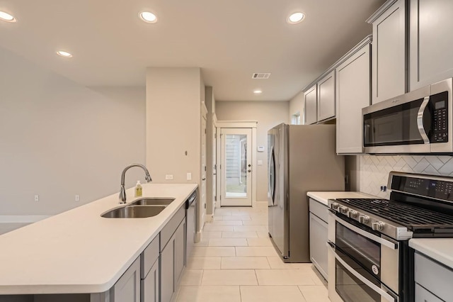 10610 Wills Loop, Austin, TX 78717 - kitchen featuring stainless steel appliances, gray cabinets, a peninsula, light countertops, and light tile patterned flooring