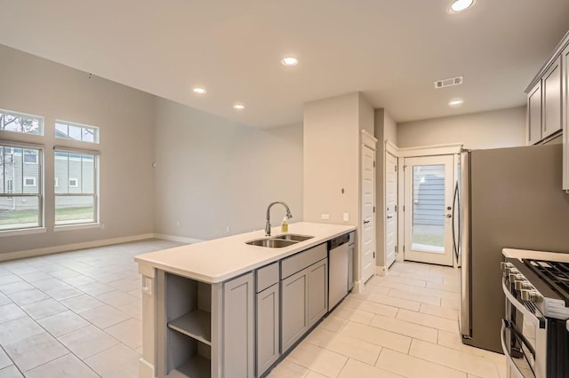 10610 Wills Loop, Austin, TX 78717 - kitchen featuring appliances with stainless steel finishes, light tile patterned floors, gray cabinetry, recessed lighting, and open shelves